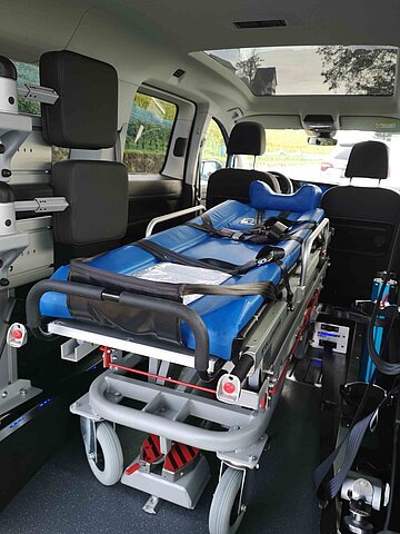 Das Bild zeigt eine Transportliege im Innenraum eines Fahrzeugs mit Heckausschnitt 86